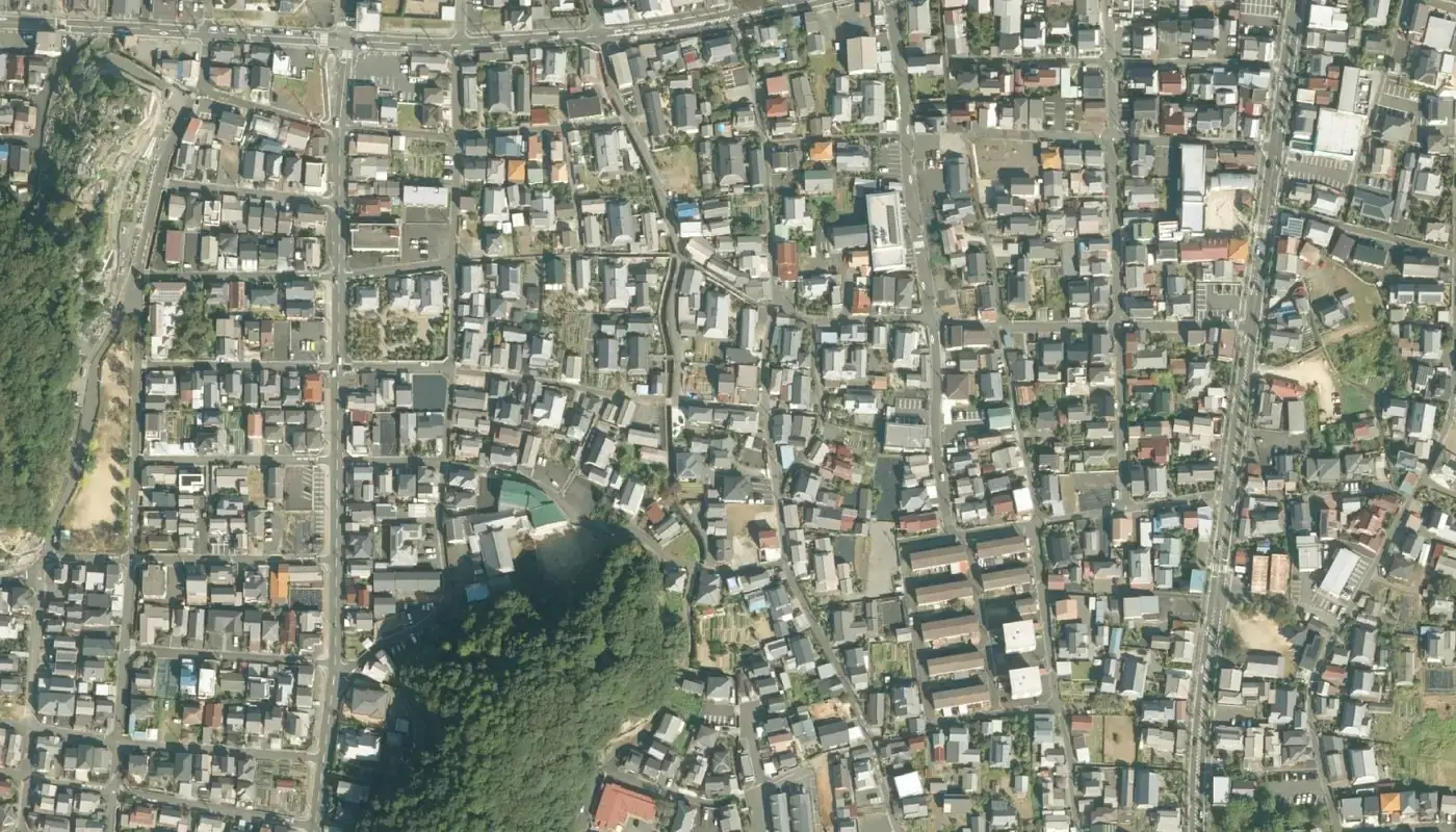 舞鶴市東舞鶴の住宅地を真上から見た空中写真。碁盤の目の道に沿って、一戸建ての屋根がすき間なく並ぶ